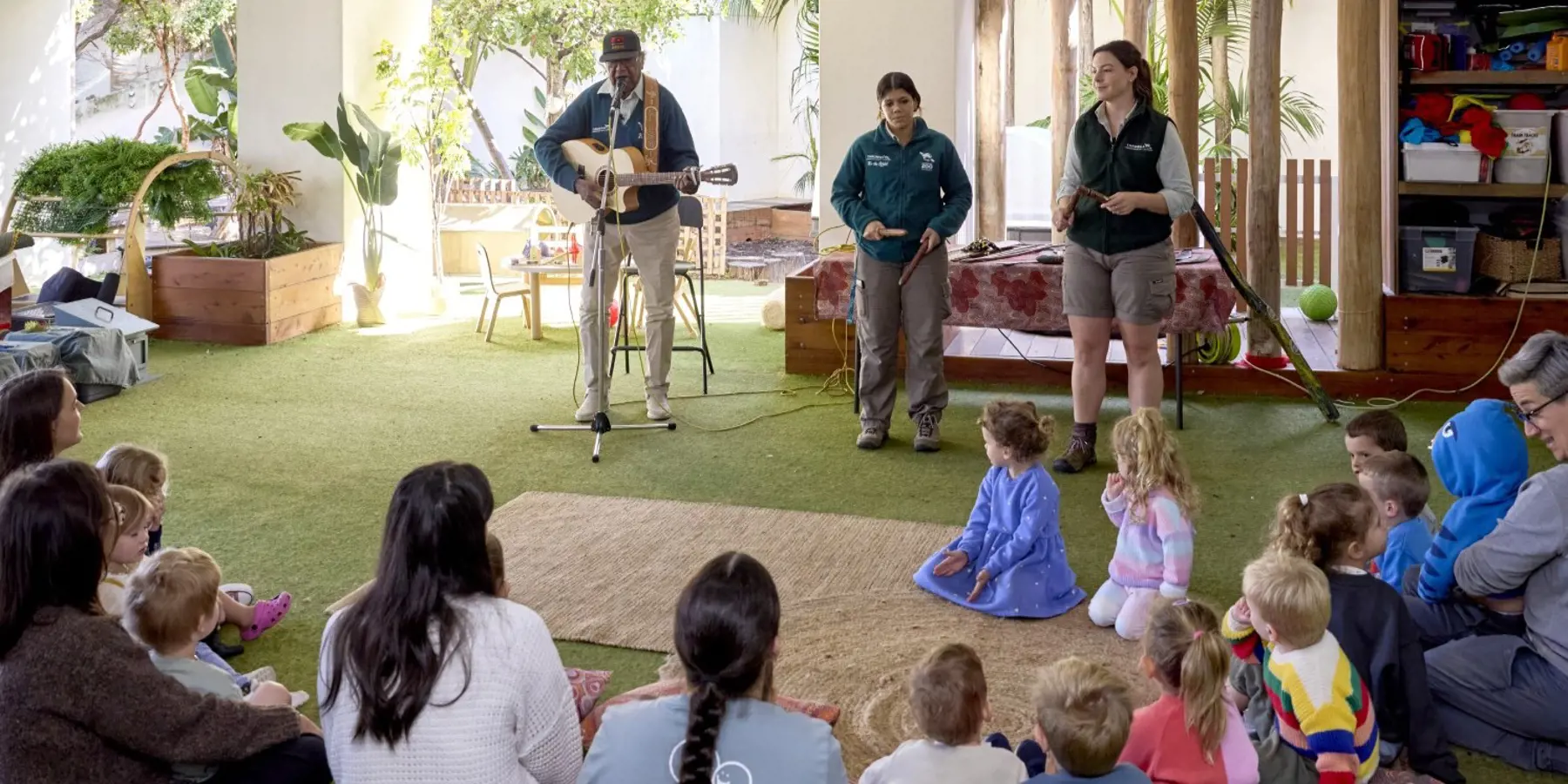Vacation care group sitting on ground watching Animals of the Dreaming workshop performances by Colin Hardy