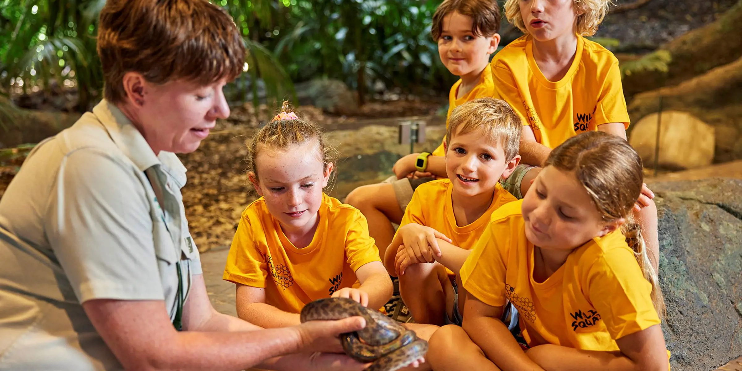 Children participating in a Zoo Adventures holiday program while observing a native animal.
