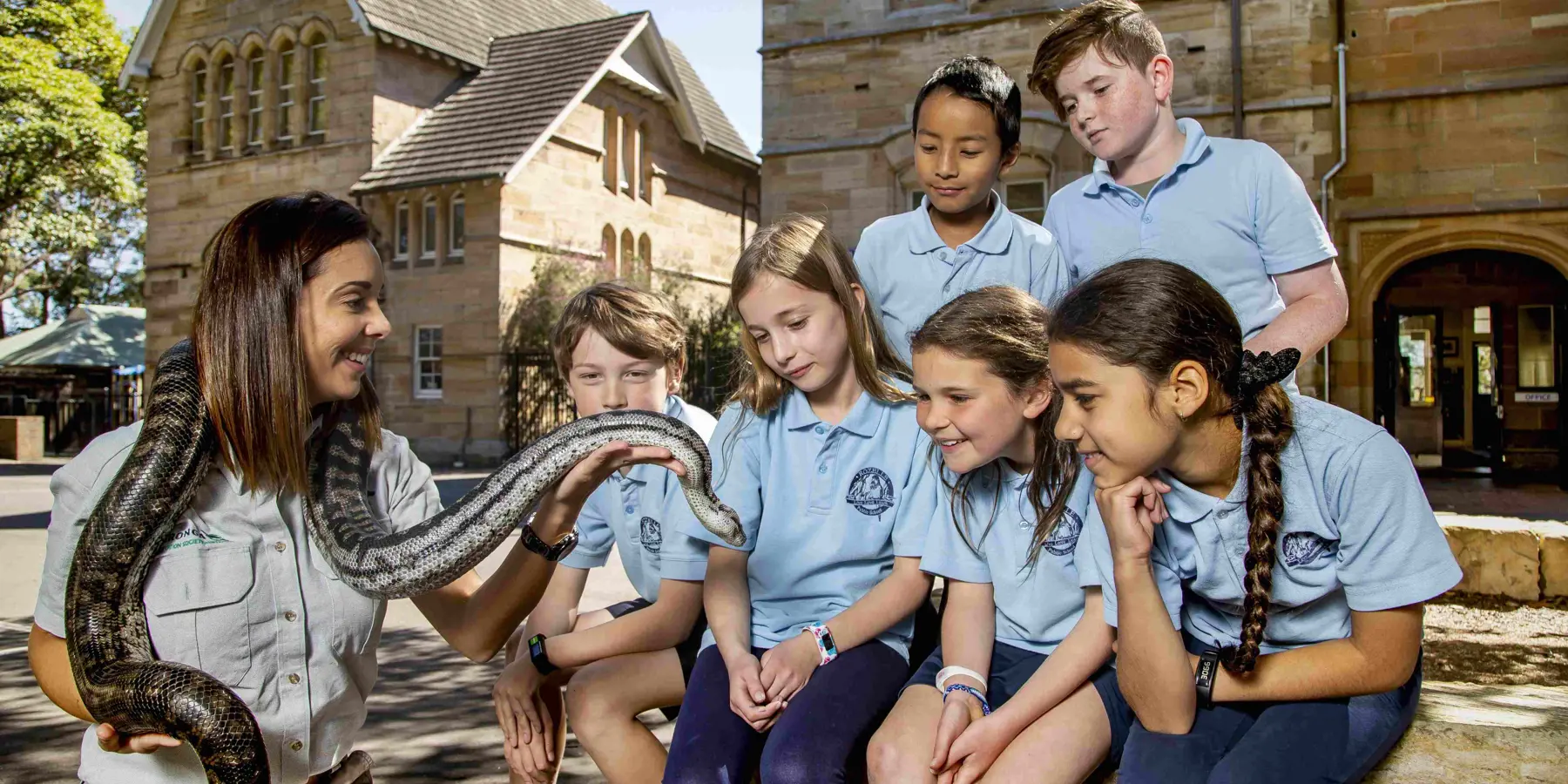 School students observing a snake during a Zoomobile wildlife education session.