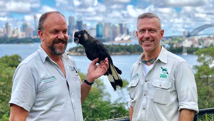 Matt Kettle (left) and Hayden Turner (right) with Marco the Carnaby Black Cockatoo