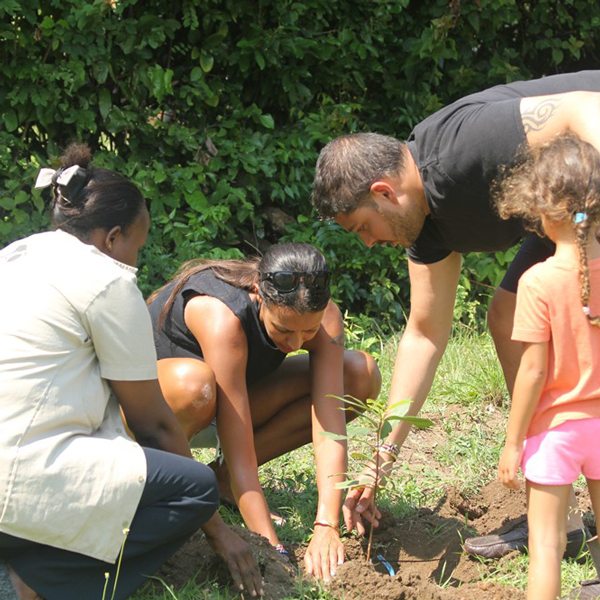 A family participating in a tree planting activity aimed at restoring wildlife migratory corridors. Credit: Colobus Conservation