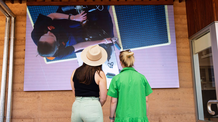 Guests observing hospital staff conduct a raptor assessment on TV monitors